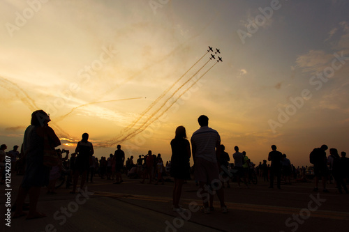 People taking pictures on a airshow at sunset