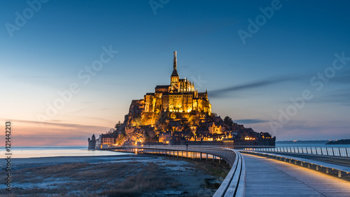 Mont saint michel Illuminated architecture panoramic beautiful postcard view at Dusk in Summer Low Tide from the bridge with reflection, France
