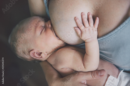 Mother breastfeeding her newborn baby boy. Mom nursing small kid.