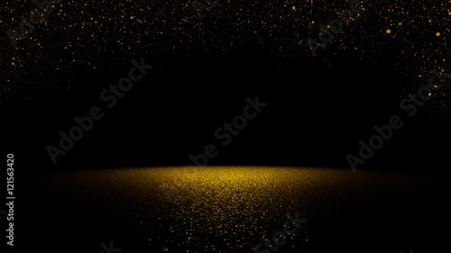 twinkling golden glitter falling on a flat surface lit by a bright spotlight 
