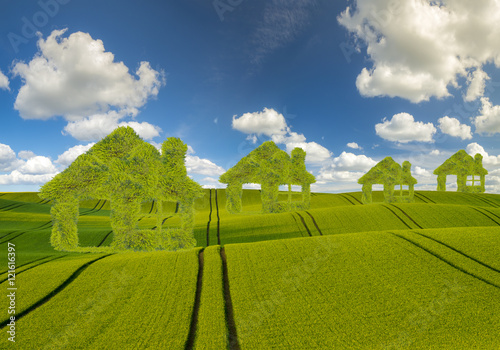 Koncepcja ekologicznych,zielonych domów na tle błękitnego nieba 