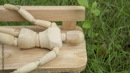 wooden human figure sleep bench garden