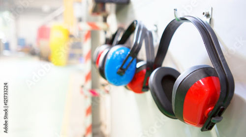 Row of Ear Defenders hung up in a factory with copy space