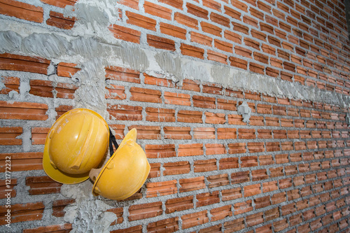 brick wall with yellow safety helmet