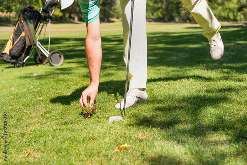 Golf. Golfer repairing divot