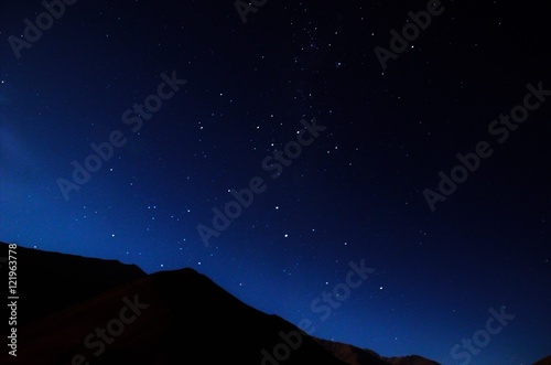 Stargazing in Elqui Valley with hundreds of stars in the sky between black hills in Chile, South America