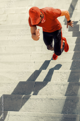 Man runner running on stairs in city, sport training.