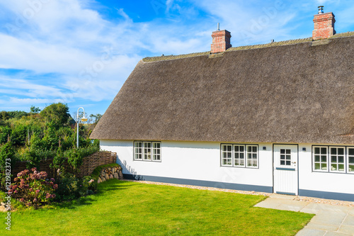 Traditional white house with thatched roof in Wenningsted village on Sylt island, Germany