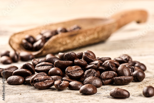 Roasted coffee beans with old wooden scoop
