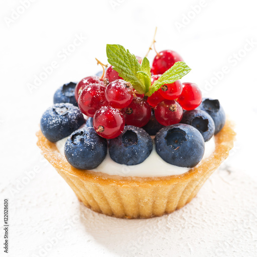 mini tart with cream and berries on white background, closeup