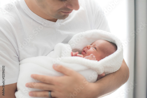 Newborn baby in Hispanic dad's arms