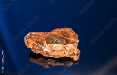 Radial blurred background view of bauxite mineral under sun light on black background