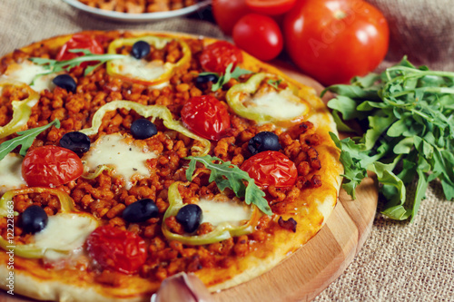 Pizza bolognese on a wooden board.