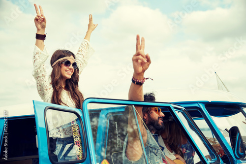 hippie friends over minivan car showing peace sign