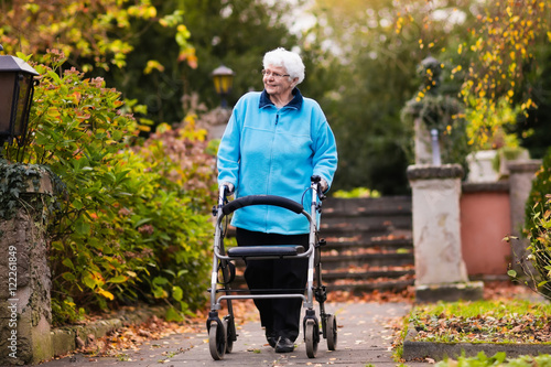 Senior lady with a walker in autumn park