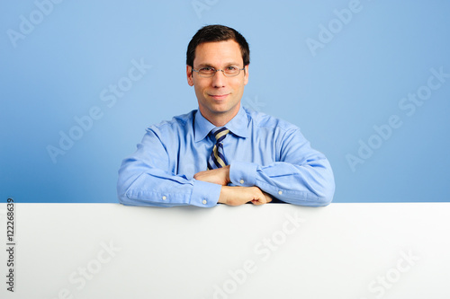 Businessman with White Board on Blue Background