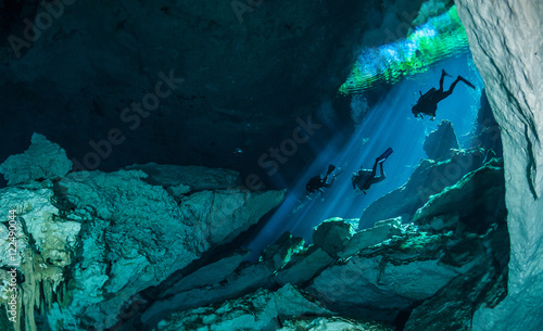 Divers descending into the waters of a cenote on the west coast of mexico's Yucatan Peninsula