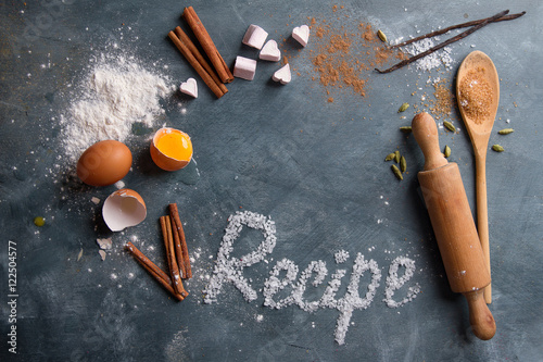 Wooden kitchen utensils with spices and recipe word