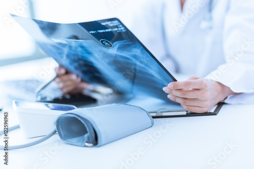 Woman Doctor Looking at X-Ray Radiography in patient's Room