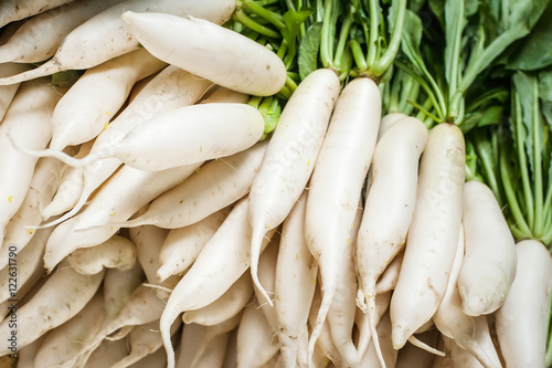 Organic local daikon radish vegetables for sale at outdoor asian marketplace