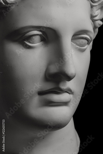 Gypsum statue of Apollo's head on a black background