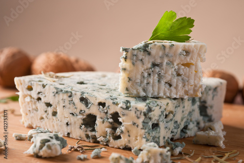 Slice of French Roquefort cheese with walnuts, copy space.