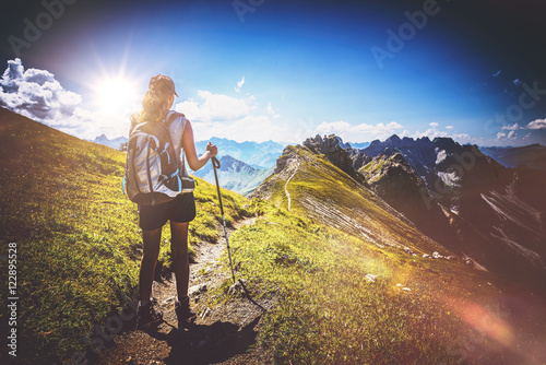 Hiker in boots and backpack holds walking stick