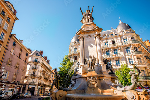City street view with fountain of Three Orders in the old town of Grenoble city on the soth-east of France