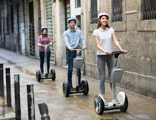 Three friends driving segways .