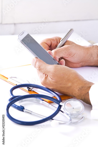 stethoscope with doctor's hands and mobile phone