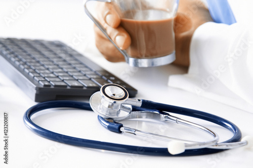 stethoscope with doctor's hands and coffee