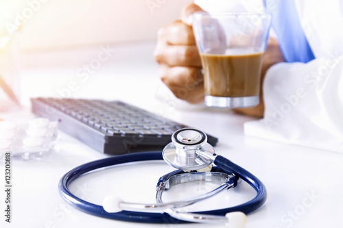 stethoscope with doctor's hands and coffee