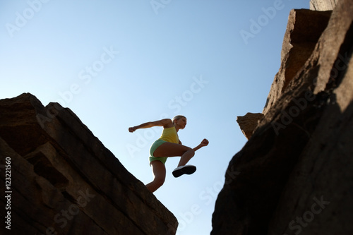 Low angle view of a girl jumping in mountains
