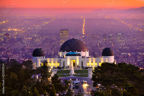Historic famous Griffith Park Observatory at Sunset with Los Angeles city lights sparkling in background and Catalina Island in distance