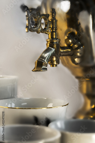Close-up Russian Teapot with Water Fountain and Cups Close Up view of water fountain on Russian teapot and set of tea cups 