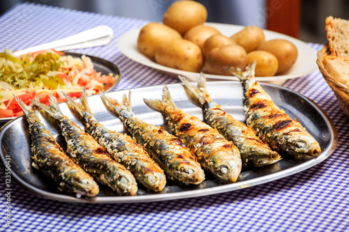 Grilled sardines with salad, bread and potato