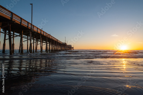 Tide coming in during a beautiful Dramatic Sunset at Newport beach Pier in Orange county, California