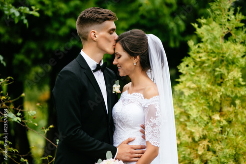 The groom kisses his sweetheart bride at their wedding after ceremony. Wedding day. 