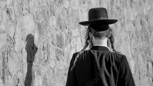 Jew Hasid ethnic headdress. Human shadow on stone wall.