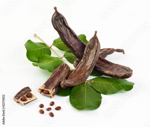 Fresh carob on white background