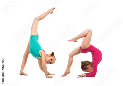 Flexible kids gymnasts doing acrobatic feat, isolated on white background