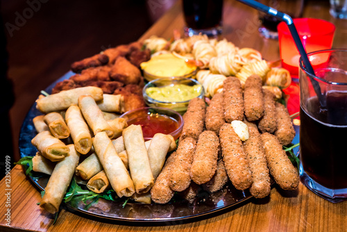 Silver plate full of appetizers finger food starters at party.