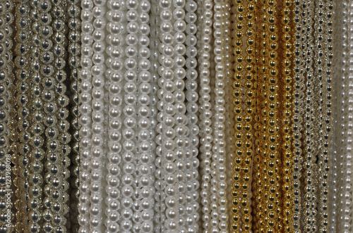 background of precious necklaces of gold beads silver and white