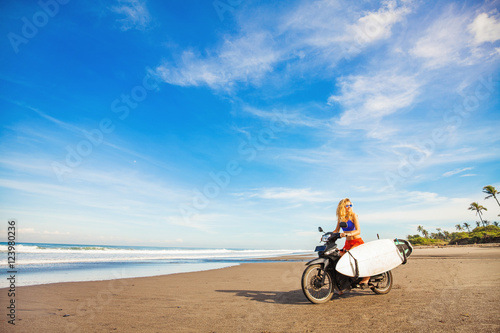 wonderful trip - woman riding a motorcycle with the surfboard