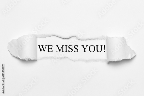 We miss you! on white torn paper