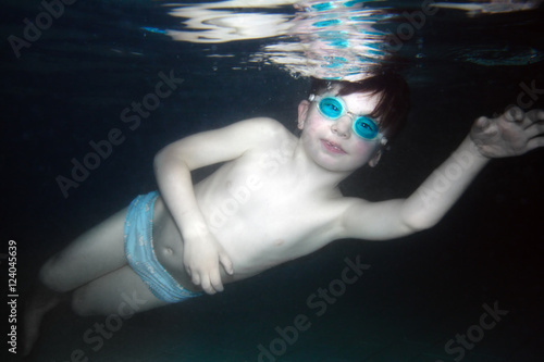 Young boy swimming underwater. Static apnea freediving discipline.