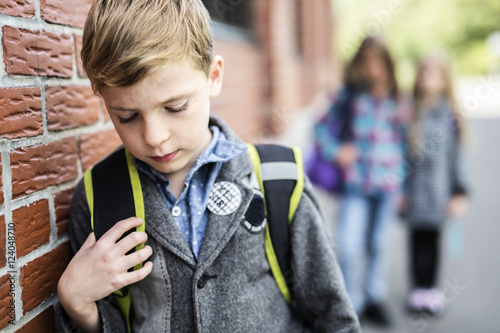 Pupils friends teasing a pupil alone primary school