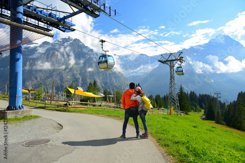 Young couple of travelers enjoying a mountains view in the summe