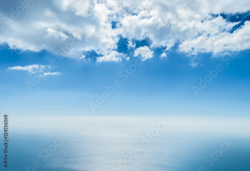 cloudy blue sky and the sea divided by the line of the horizon