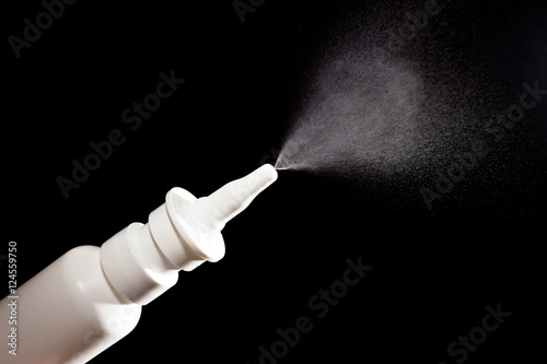 Close-up of nasal drug spraying on black